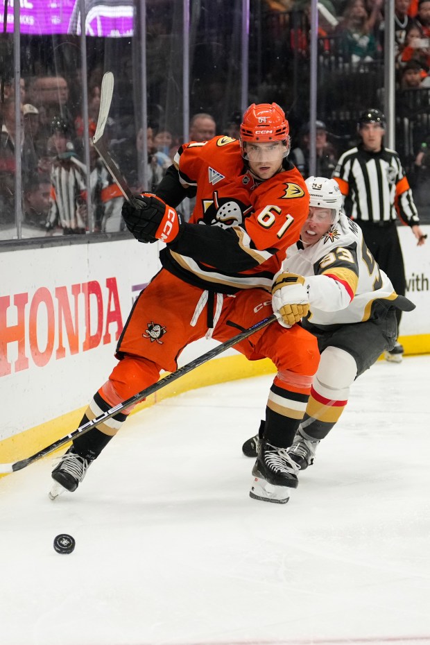Anaheim Ducks left wing Cutter Gauthier, left, passes the puck...