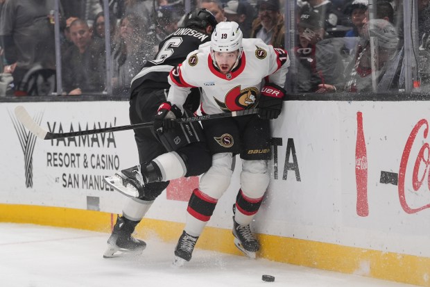 Ottawa Senators right wing Drake Batherson, right, evades a check...