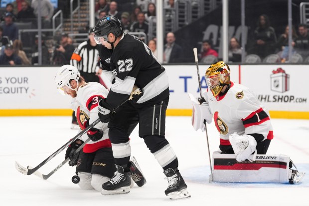 Ottawa Senators defenseman Nick Jensen, left, battles for the puck...