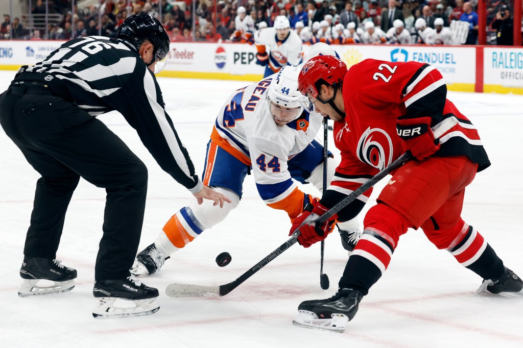 Carolina Hurricanes' Logan Stankoven (22) faces off against New York Islanders' Jean-Gabriel Pageau (44) during the first period of an NHL hockey game in Raleigh, N.C., Thursday, Oct. 30, 2025. 