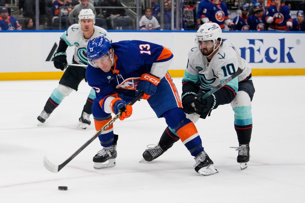 New York Islanders' Mathew Barzal (13) drives past Seattle Kraken's Matty Beniers 