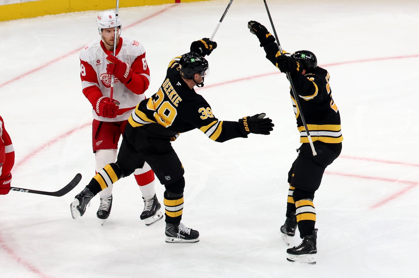 Bruins pivots Morgan Geekie (No. 39) and Alex Steeves (No. 21) celebrate Geekie's second-period goal, the first of his two on the night, that broke a scoreless stalemate against the Red Wings in a 3-2 shootout win Saturday night at TD Garden.