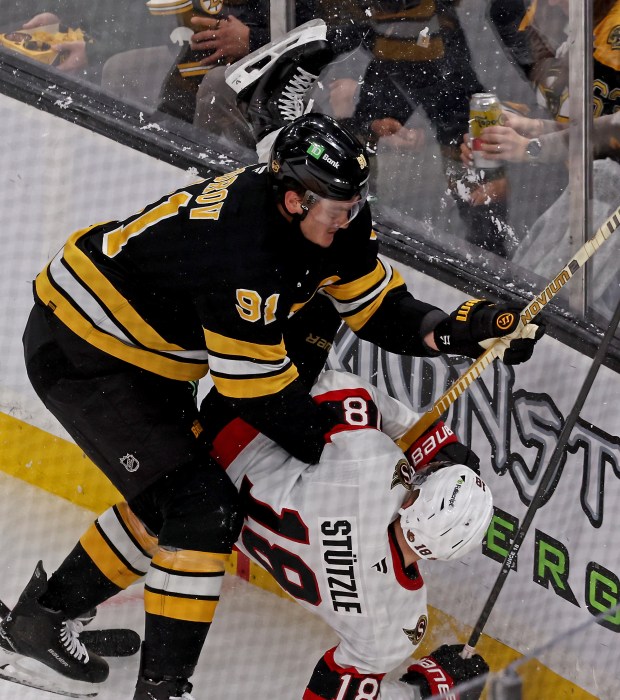 Boston Bruins defenseman Nikita Zadorov (91) checks Ottawa Senators center Tim Stützle during Thursday's game. (Staff Photo By Stuart Cahill/Boston Herald)