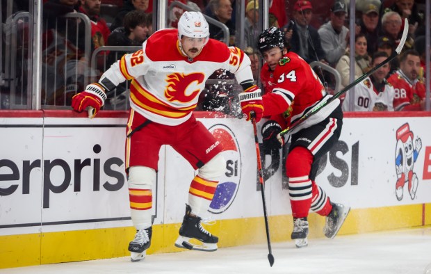 Flames defenseman MacKenzie Weegar (52) moves the puck past Blackhawks center Colton Dach (34) during the first period, Nov. 18, 2025, at the United Center. (Dominic Di Palermo/Chicago Tribune)