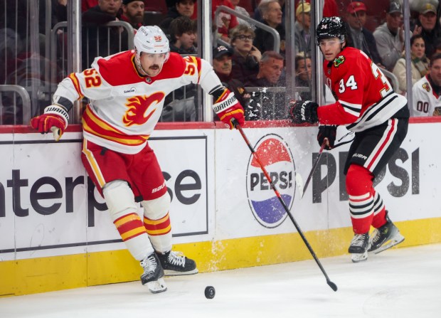Flames defenseman MacKenzie Weegar (52) moves the puck past Blackhawks center Colton Dach (34) during the first period, Nov. 18, 2025, at the United Center. (Dominic Di Palermo/Chicago Tribune)