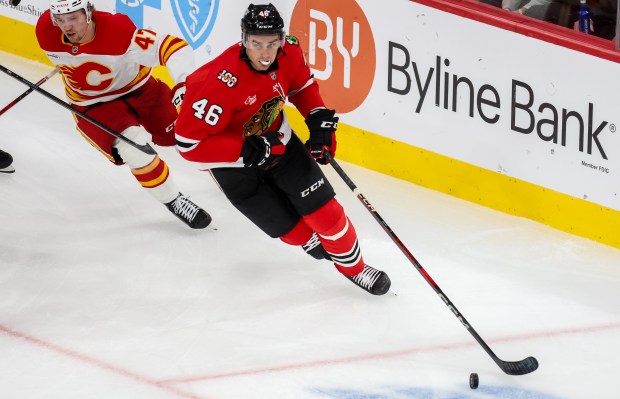 Blackhawks defenseman Louis Crevier (46) keeps the puck away from Flames center Connor Zary (47) during the third period, Nov. 18, 2025, at the United Center. (Dominic Di Palermo/Chicago Tribune)