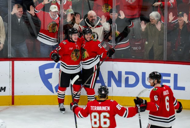 Blackhawks center Oliver Moore (11) and Blackhawks center Frank Nazar (91) celebrate his goal that brought the Blackhawks up 4-2 during the third period against the Calgary Flames, Nov. 18, 2025, at the United Center. (Dominic Di Palermo/Chicago Tribune)