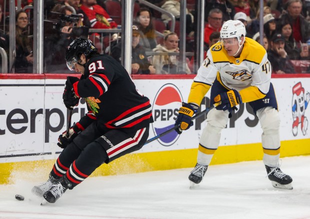 Blackhawks center Frank Nazar (91) grabs the puck away from Nashville Predators right wing Michael McCarron (47) during the second period, Nov. 28, 2025, at the United Center. (Dominic Di Palermo/Chicago Tribune)