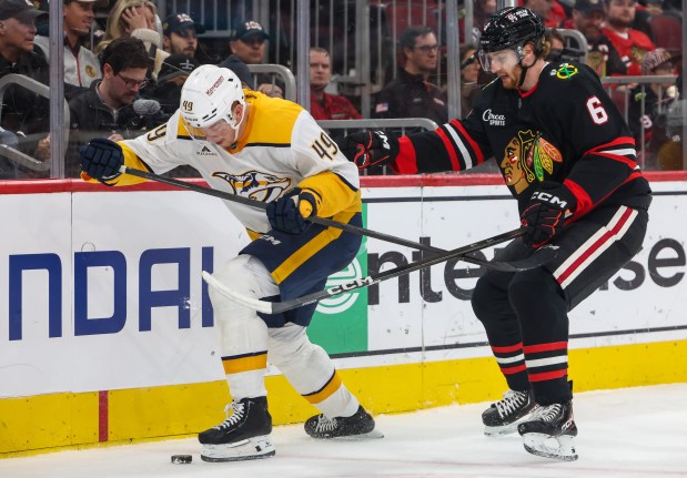 Nashville Predators left wing Reid Schaefer (49) tries to keep the puck away from Blackhawks defenseman Sam Rinzel (6) during the second period, Nov. 28, 2025, at the United Center. (Dominic Di Palermo/Chicago Tribune)