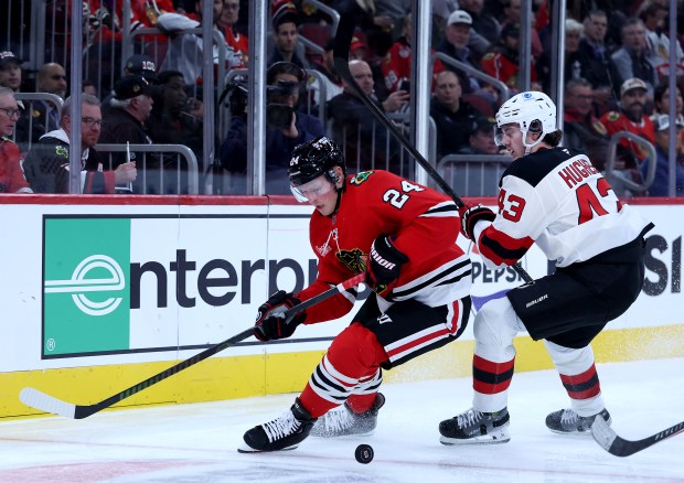 Blackhawks center Sam Lafferty and Devils defenseman Luke Hughes battle in the first period Wednesday, Nov. 12, 2025, at the United Center. (Chris Sweda/Chicago Tribune)