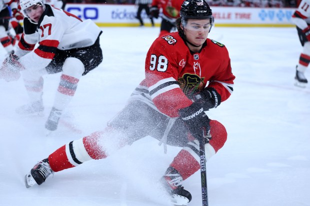 Blackhawks center Connor Bedard battles against Devils defenseman Simon Nemec in the third period Wednesday, Nov. 12, 2025, at the United Center. (Chris Sweda/Chicago Tribune)