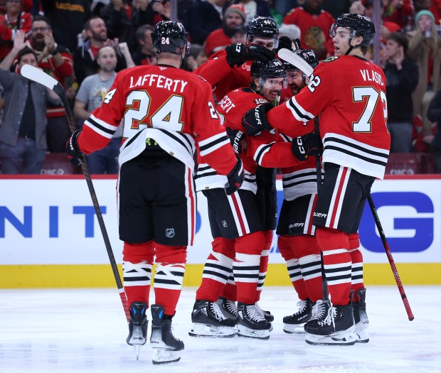 Blackhawks left wing Landon Slaggert (84) is surrounded by his teammates after scoring a goal in the third period against the Devils on Wednesday, Nov. 12, 2025, at the United Center. (Chris Sweda/Chicago Tribune)