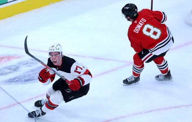 Devils defenseman Simon Nemec (17) celebrates his game-winning goal in overtime against center Ryan Donato (8) and the Blackhawks on Wednesday, Nov. 12, 2025, at the United Center. (Chris Sweda/Chicago Tribune)