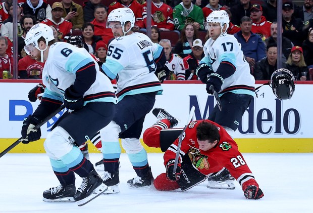 Chicago Blackhawks left wing Andre Burakovsky (28) loses his helmet as he falls to the ice in the first period of a game against the Seattle Kraken at the United Center in Chicago on Nov. 20, 2025. (Chris Sweda/Chicago Tribune)