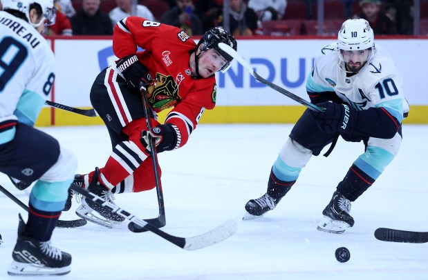 Chicago Blackhawks center Ryan Donato (8) and Seattle Kraken center Matty Beniers (10) battle in the third period of a game at the United Center in Chicago on Nov. 20, 2025. (Chris Sweda/Chicago Tribune)
