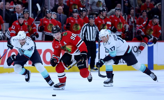 Chicago Blackhawks center Connor Bedard (98) skates down the ice before failing to score as Seattle Kraken defenseman Ryan Lindgren (55) and left wing Jaden Schwartz (17) trail on the play in the third period of a game at the United Center in Chicago on Nov. 20, 2025. (Chris Sweda/Chicago Tribune)