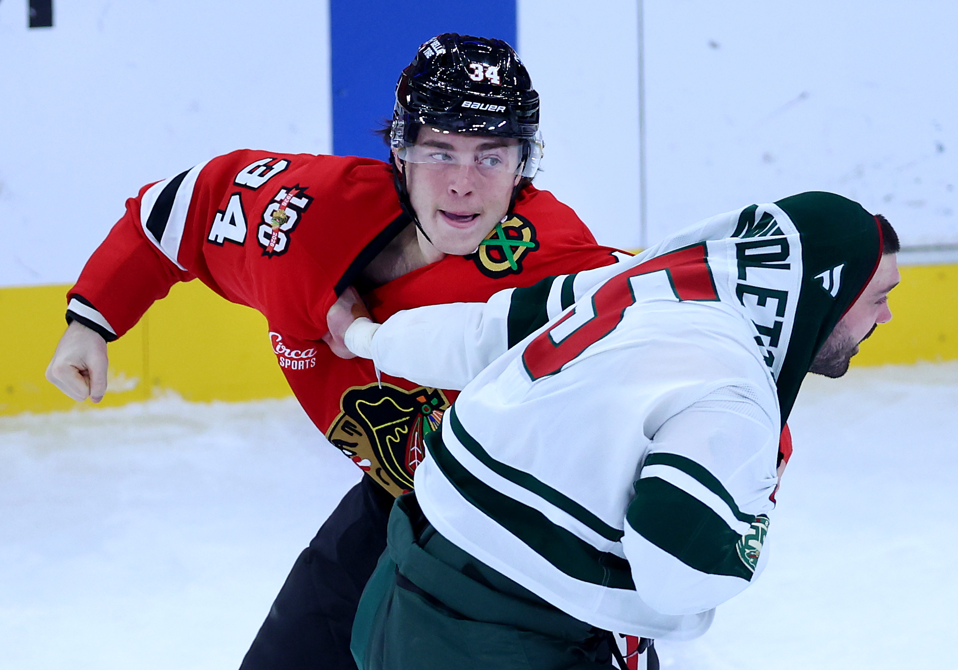 Chicago Blackhawks center Colton Dach (left) and Minnesota Wild defenseman Jake Middleton (5) fight in the second period of a game at the United Center in Chicago on Nov. 26, 2025. (Chris Sweda/Chicago Tribune)