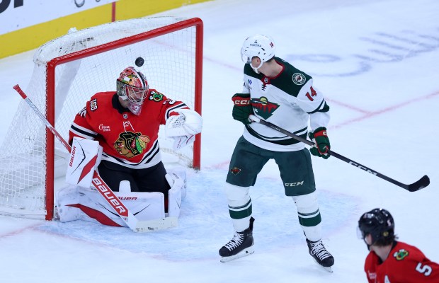 Chicago Blackhawks goaltender Spencer Knight (30) is unable to stop the puck as Minnesota Wild left wing Kirill Kaprizov scores the winning goal in overtime of a game at the United Center in Chicago on Nov. 26, 2025. (Chris Sweda/Chicago Tribune)
