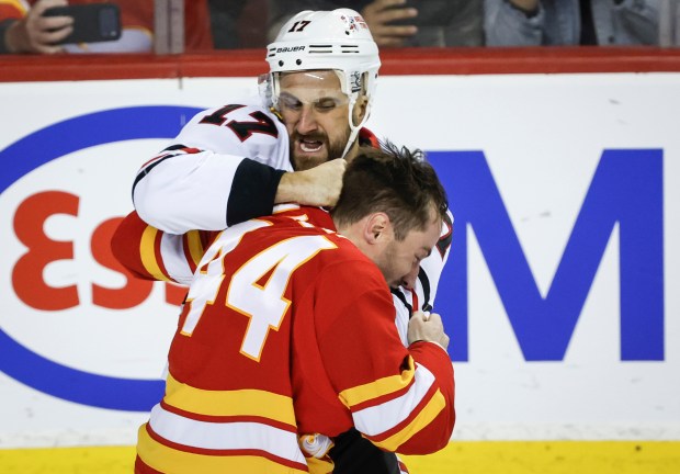 Chicago Blackhawks' Nick Foligno, top, fights with Calgary Flames' Joel Hanley, bottom, during second-period NHL hockey game action in Calgary, Alberta, Friday, Nov. 7, 2025. (Jeff McIntosh/The Canadian Press via AP)