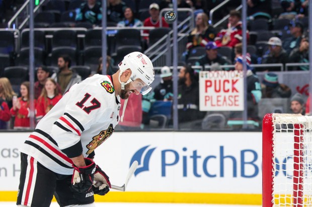 Chicago Blackhawks left wing Nick Foligno (17) head butts a puck into the net during warmups before an NHL hockey game against the Seattle KrakenMonday, Nov. 3, 2025, in Seattle. (AP Photo/Jason Redmond)