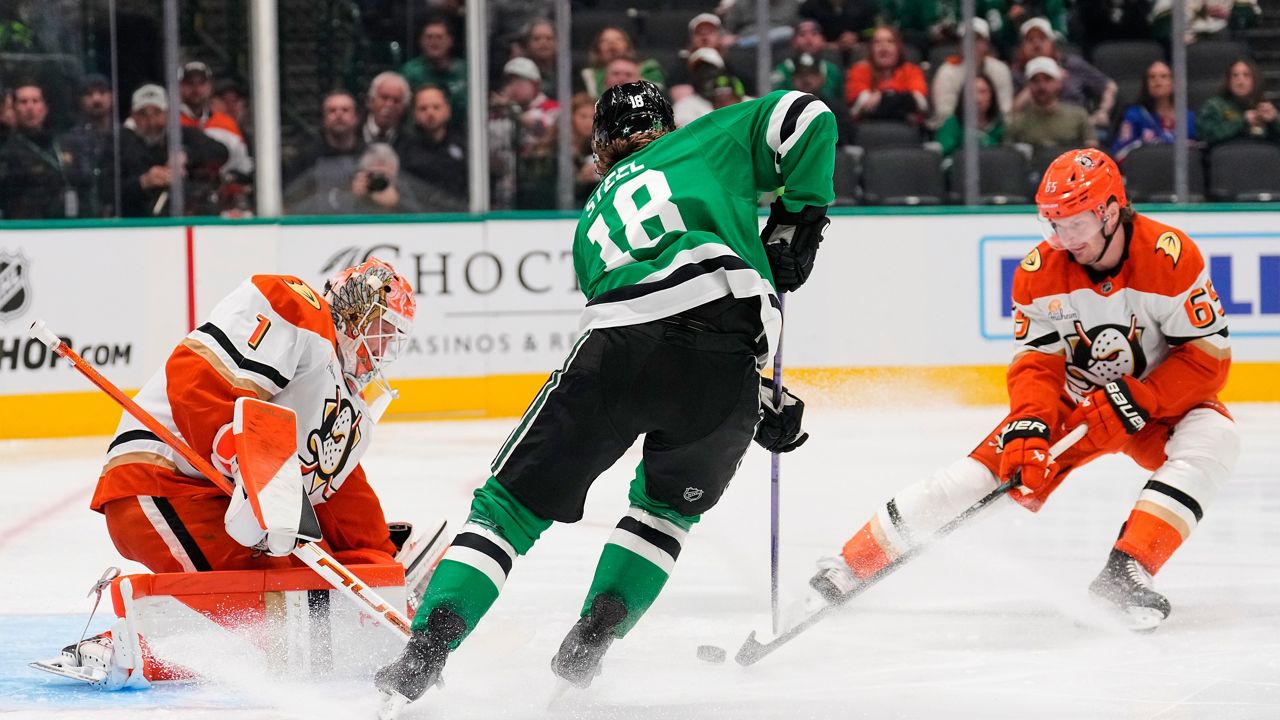 Dallas Stars goaltender Jake Oettinger (29) gloves a shot from Anaheim Ducks' Ryan Poehling (25) as Colin Blackwell (15) helps defend on the play in the second period of an NHL hockey game Thursday, Nov. 6, 2025, in Dallas. (AP Photo/Tony Gutierrez)
