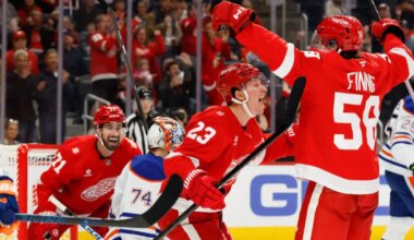 Oct 19, 2025; Detroit, Michigan, USA; Detroit Red Wings center Emmitt Finnie (58) celebrates with left wing Lucas Raymond (23) and center Dylan Larkin (71) after scoring a goal against the Edmonton Oilers during the second period at Little Caesars Arena.