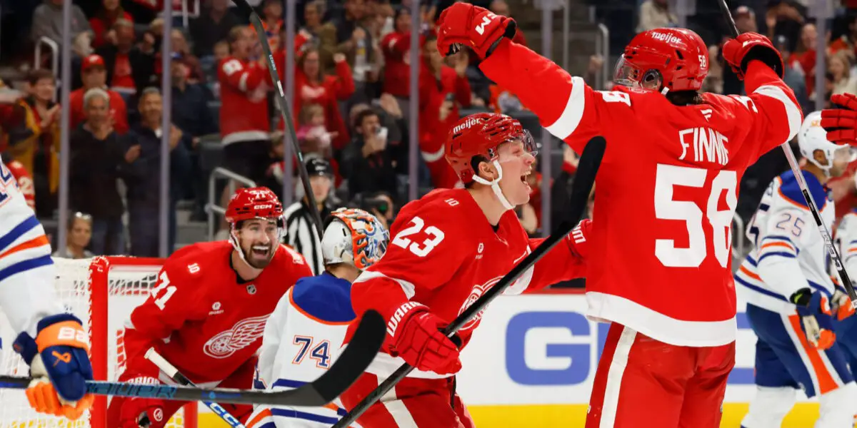Oct 19, 2025; Detroit, Michigan, USA; Detroit Red Wings center Emmitt Finnie (58) celebrates with left wing Lucas Raymond (23) and center Dylan Larkin (71) after scoring a goal against the Edmonton Oilers during the second period at Little Caesars Arena.