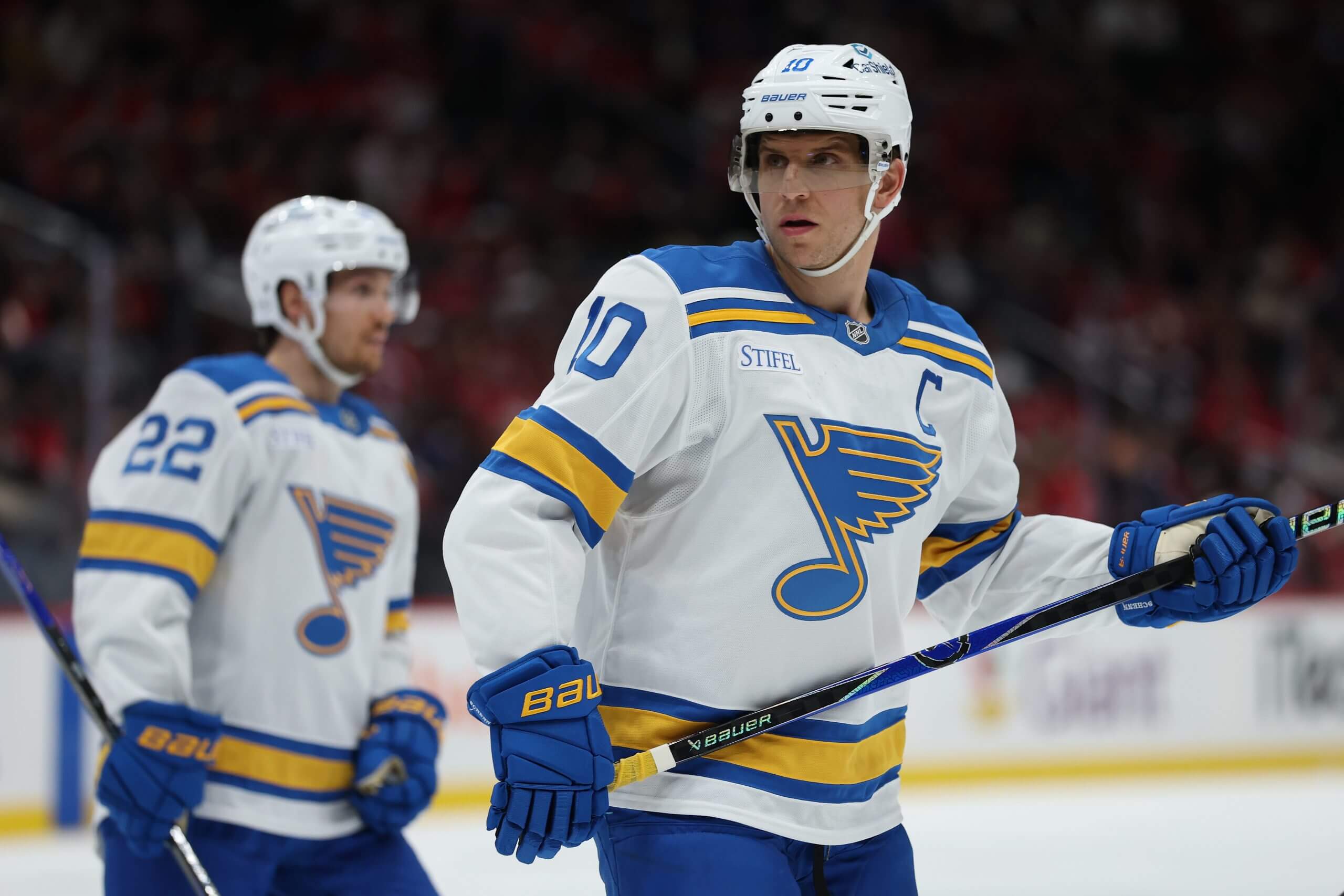 Brayden Schenn looks into the distance with Pius Suter in the background.