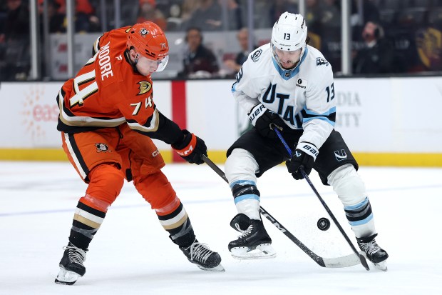 The Ducks’ Ian Moore, left, and the Utah Mammoth’s Brandon...