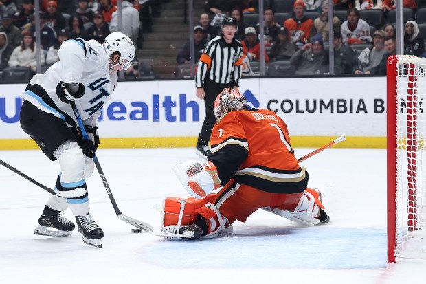 Ducks goaltender Lukas Dostal, right, blocks a shot on goal...