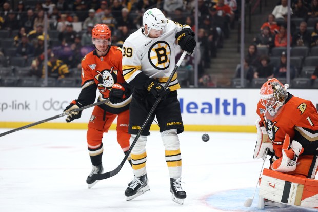 The Boston Bruins’ Morgan Geekie, center, deflects a shot on...
