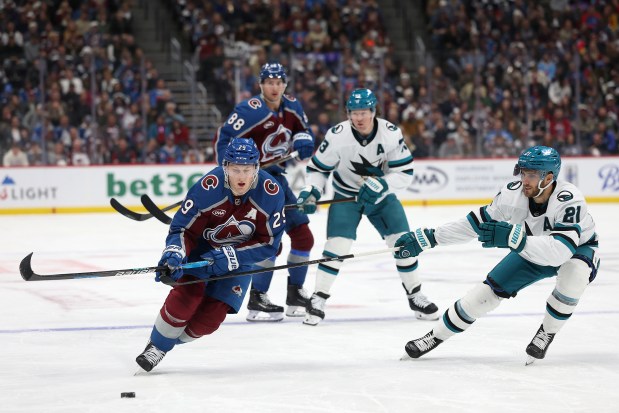DENVER, COLORADO - NOVEMBER 26: Nathan MacKinnon #29 of the Colorado Avalanche advances the puck against Alexander Wennberg #21 of the San Jose Sharks in the second period at Ball Arena on November 26, 2025 in Denver, Colorado. (Photo by Matthew Stockman/Getty Images)
