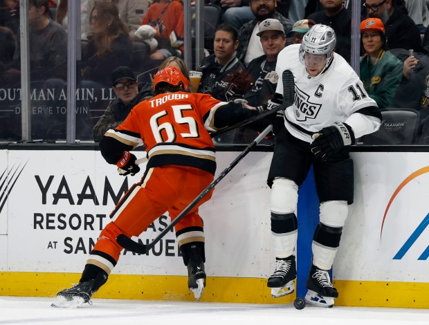 Kings captain Anze Kopitar, right, skates around the Ducks’ Jacob...