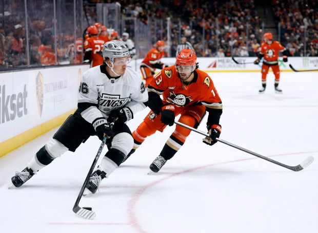 The Kings’ Andrei Kuzmenko, left, skates with the puck as...