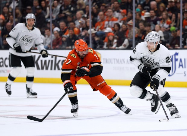 The Kings’ Kevin Fiala, right, skates as he is checked...