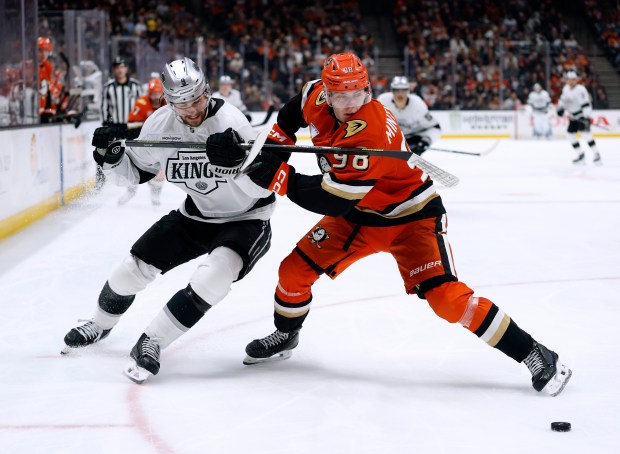 The Kings’ Adrian Kempe, left, and the Ducks’ Pavel Mintyukov...