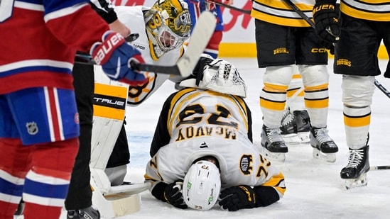 Nov 15, 2025; Montreal, Quebec, CAN; Boston Bruins goalie Jeremy Swayman (1) checks on teammate Boston Bruins defenseman Charlie McAvoy (73) who got hit by a shot in the face during the second period of the game against the Montreal Canadiens at the Bell Centre.(IMAGN IMAGES via Reuters Connect)