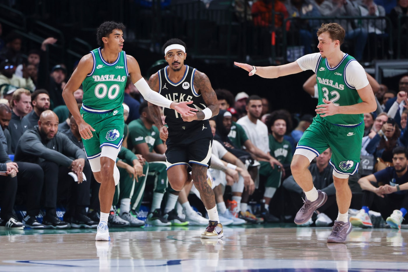 Dallas Mavericks guard Max Christie (00) cheers with forward Cooper Flagg (32) following...