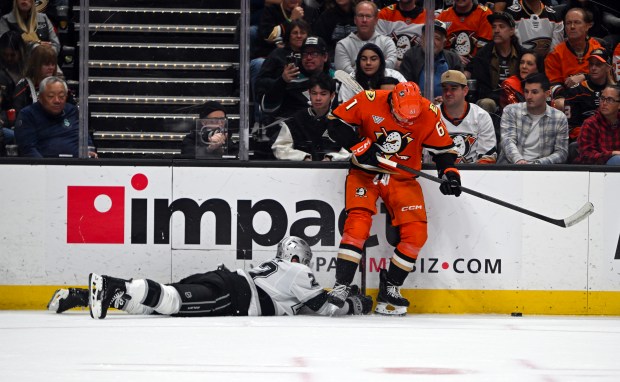 The Kings’ Brian Dumoulin dives for the puck as the...