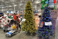 Shoppers pass by holiday trees on display in a Costco warehouse Tuesday, Oct. 14, 2025, in...