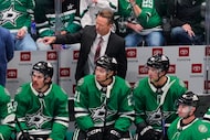 Dallas Stars head coach Glen Gulutzan, center standing, watches play during an NHL hockey...