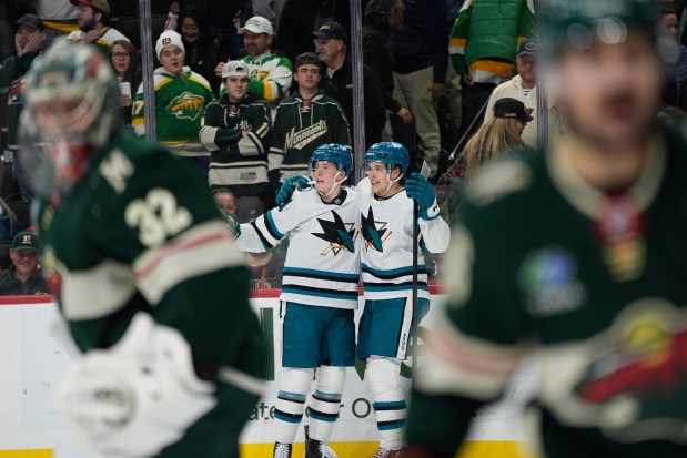 San Jose Sharks right wing Collin Graf, center left, celebrates with center Macklin Celebrini after scoring the game-winning goal during overtime of an NHL hockey game against the Minnesota Wild, Tuesday, Nov. 11, 2025, in St. Paul, Minn. (AP Photo/Abbie Parr)