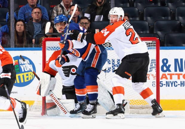 Nick Seeler, 24, of the Philadelphia Flyers moves Anders Lee, 27, of the New York Islanders from the crease during the first period at UBS Arena on November 28, 2025 in Elmont, New York. (Photo by Bruce Bennett/Getty Images)
