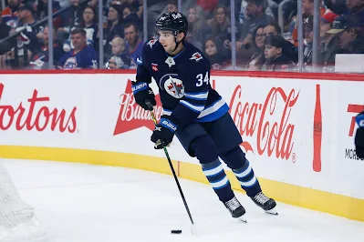 Winnipeg Jets defenseman Ville Heinola skates with the puck during 2025 game. Winnipeg Jets defenseman Ville Heinola skates with the puck during 2025 game.