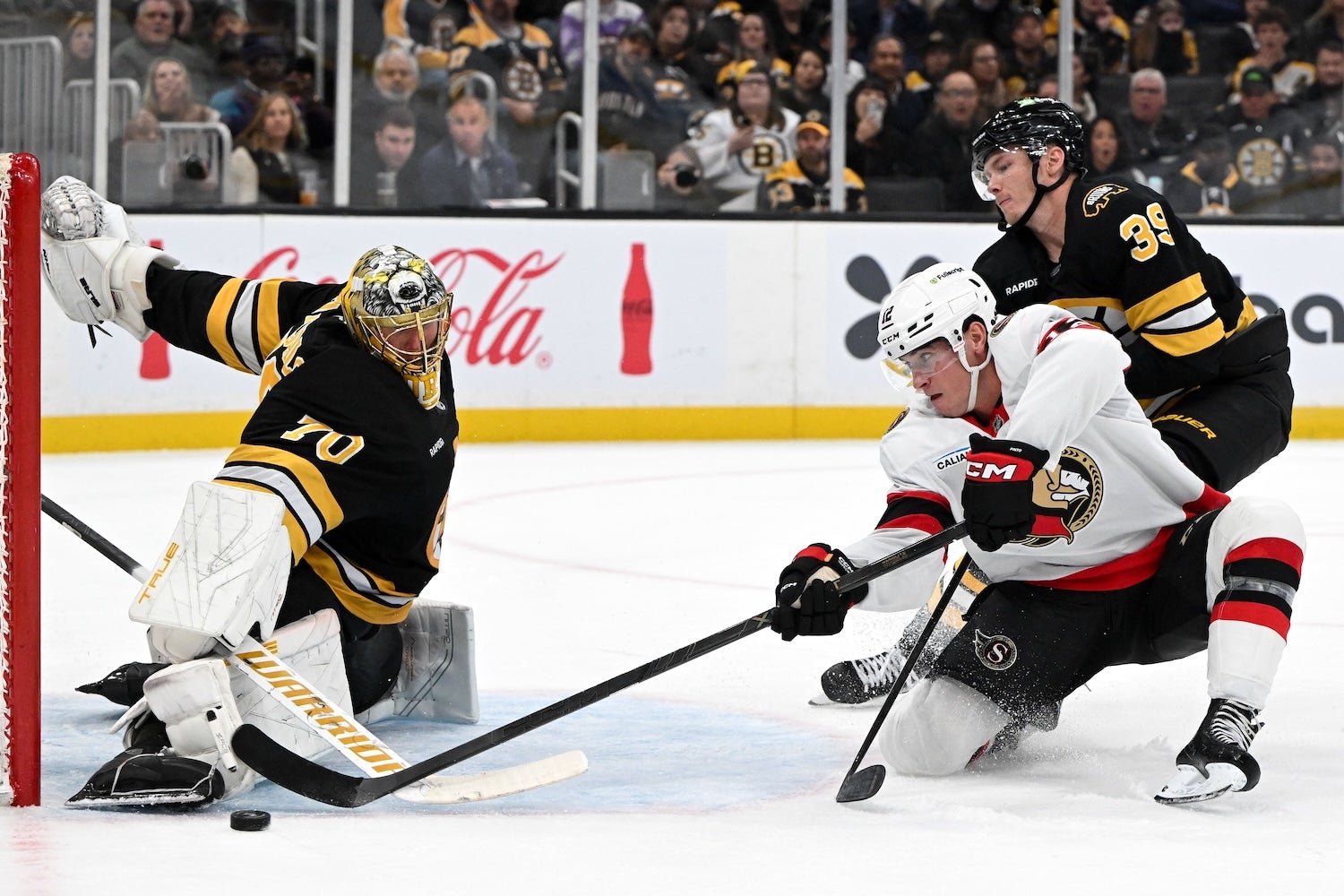 Nov 6, 2025; Boston, Massachusetts, USA; Boston Bruins goaltender Joonas Korpisalo (70) makes a save on a shot by Ottawa Senators center Shane Pinto (12) during overtime at the TD Garden. Mandatory Credit: Brian Fluharty-Imagn Images