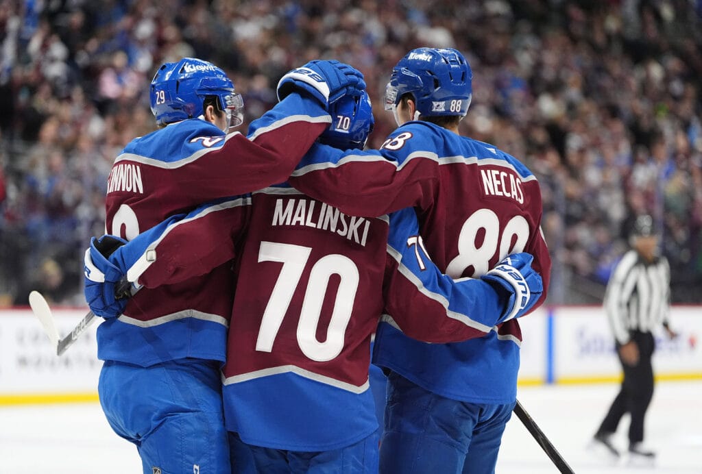 Colorado Avalanche defenseman Sam Malinski (70) celebrates his goal with center Nathan MacKinnon (29) and center Martin Necas (88) during the second period against the San Jose Sharks at Ball Arena. Mandatory Credit: Ron Chenoy-Imagn Images