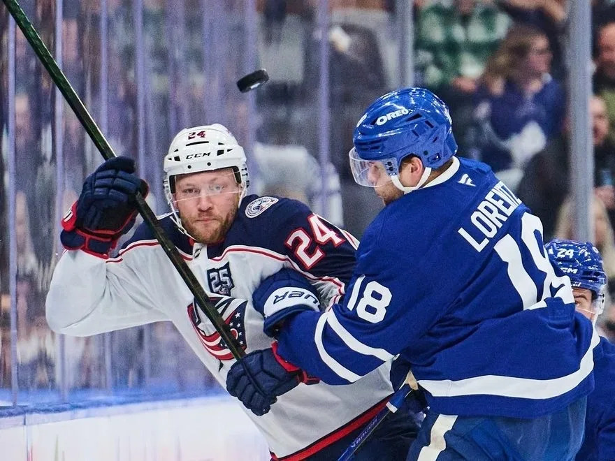  Columbus Blue Jackets forward Mathieu Olivier (24) and Maple Leafs counterpart Steven Lorentz (18) battle for the puck in Toronto on Thursday, Nov. 20, 2025.