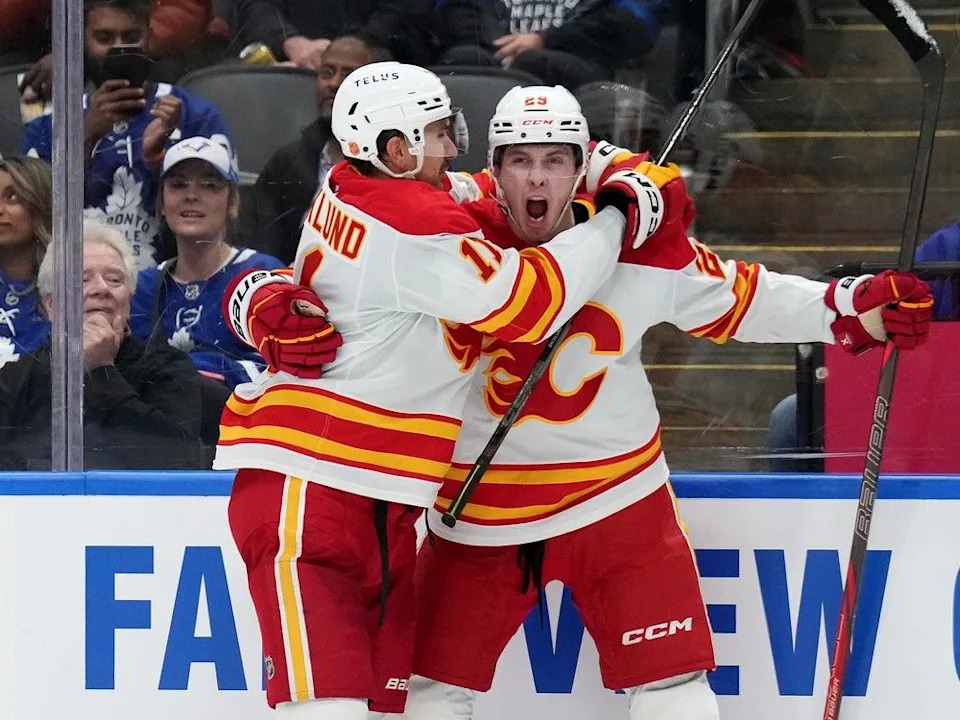  Calgary Flames forward Samuel Honzek celebrates his goal with teammate Mikael Backlund in October.