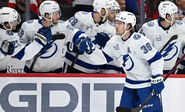 Tampa Bay Lightning left wing Brandon Hagel (38) is congratulated by his teammates after scoring his second goal during the first period of an NHL hockey game against the Tampa Bay Lightning, Saturday, Nov. 22, 2025, in Washington. (AP Photo/John McDonnell)