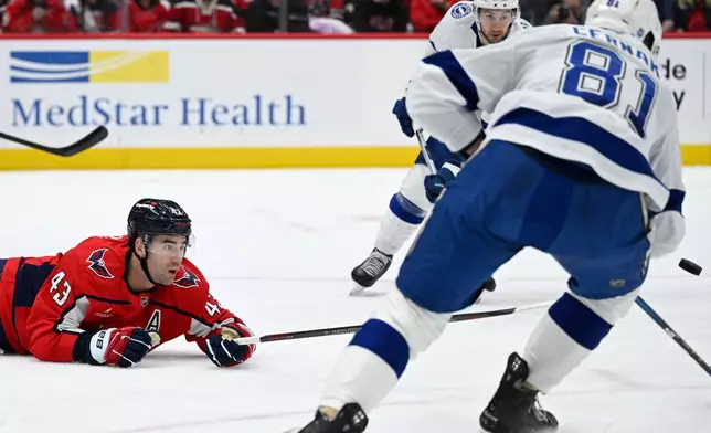 Washington Capitals right wing Tom Wilson (43) dives for a loose puck during the first period of an NHL hockey game against the Tampa Bay Lightning, Saturday, Nov. 22, 2025, in Washington. (AP Photo/John McDonnell)